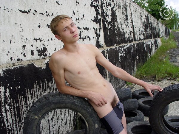 Naked Max enjoys playing with tires in the sun