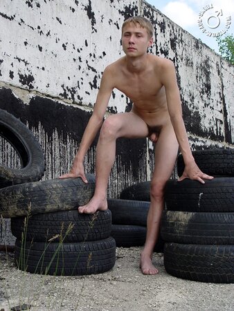 Naked Max enjoys playing with tires in the sun