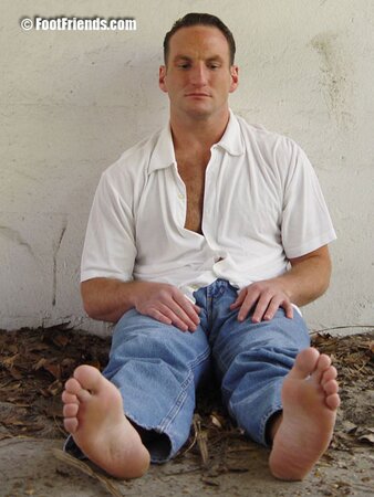 Duke reveals his thick soles and toes after removing his black socks