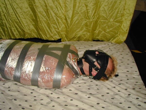 Bondage masters mummify a guest Craig in a plastic wrap