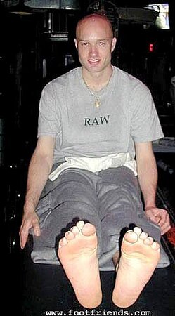 Robert greets men at the door while showing off his sexy bare feet