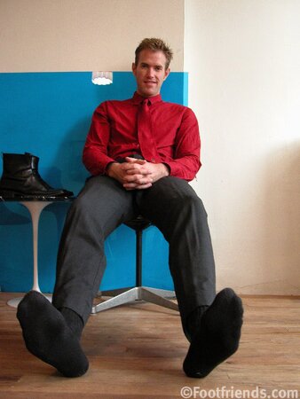 Kurt shows off his size 13 feet while posing in a stylish red shirt