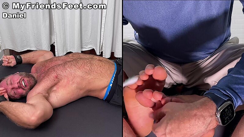 Daniel squirms as Dan Edwards tickles his bare feet