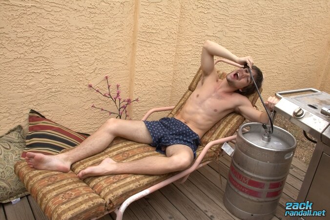 Beer in hand, Zack Randall jerks his uncut cock and cums on the keg