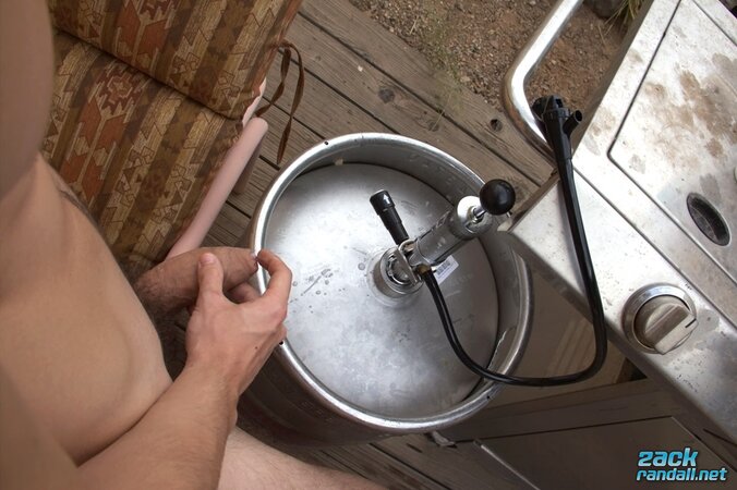 Beer in hand, Zack Randall jerks his uncut cock and cums on the keg