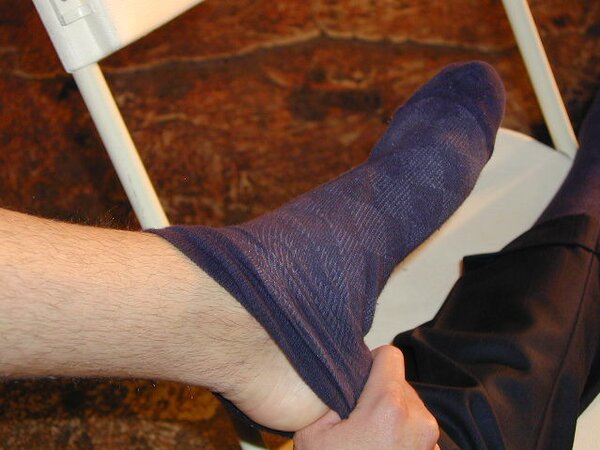 Eric’s slim feet and sheer dark socks steal the show