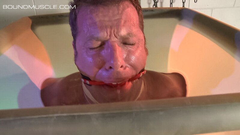 Dire Callahan traps Derek Pain in a latex coffin for pain play