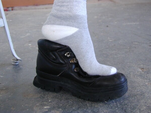 Anthony sniffs his musky leather boots and gray socks