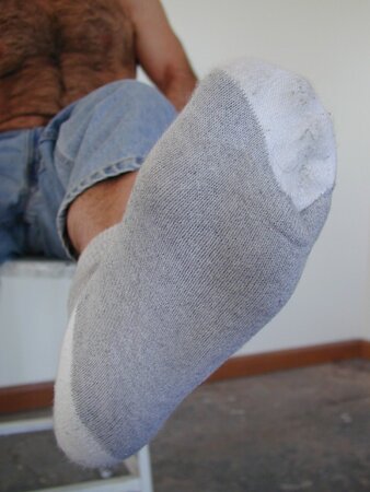 Anthony sniffs his musky leather boots and gray socks