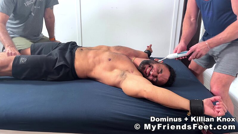 Killian Knox towers over restrained Dominus and makes him giggle