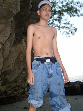 Young twink Adrial gets completely naked on the beach and strokes his cock