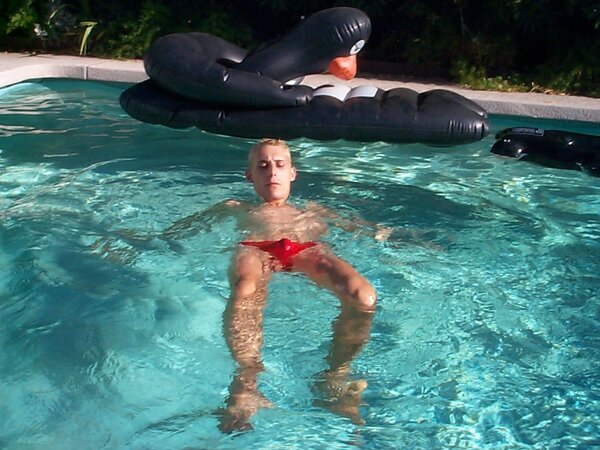 Sporty twink cools off in the pool after stroking by the water