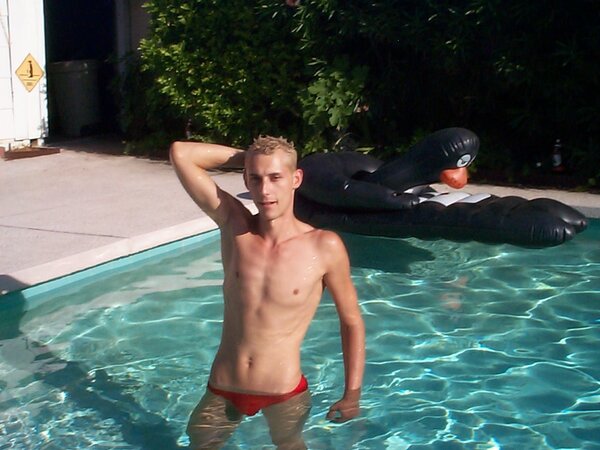 Sporty twink cools off in the pool after stroking by the water