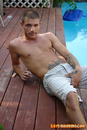 Tattooed chainsmoker Tristan Matthews lights up and strokes outside in the sun