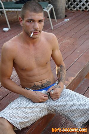 Tattooed chainsmoker Tristan Matthews lights up and strokes outside in the sun