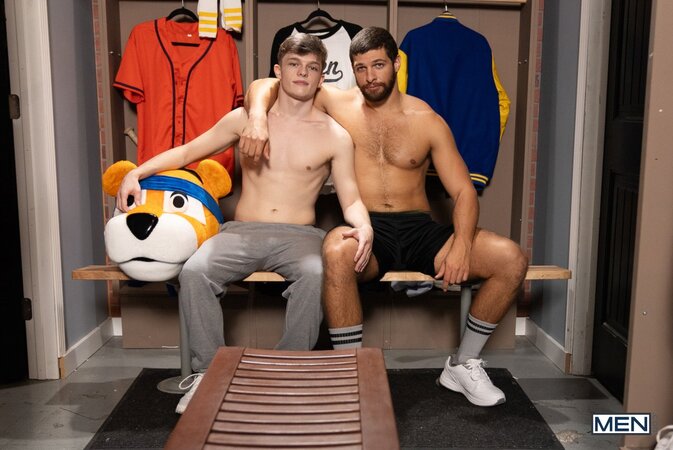 Mascot Jake Preston buries his tongue in athlete Shamu Azizam in the locker