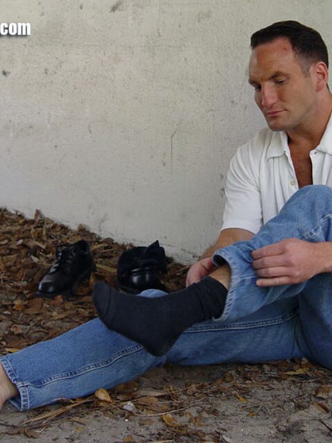 Duke reveals his thick soles and toes after removing his black socks