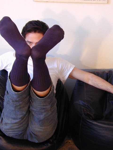 Brunette Christopher flaunts his feet in dark socks for the camera