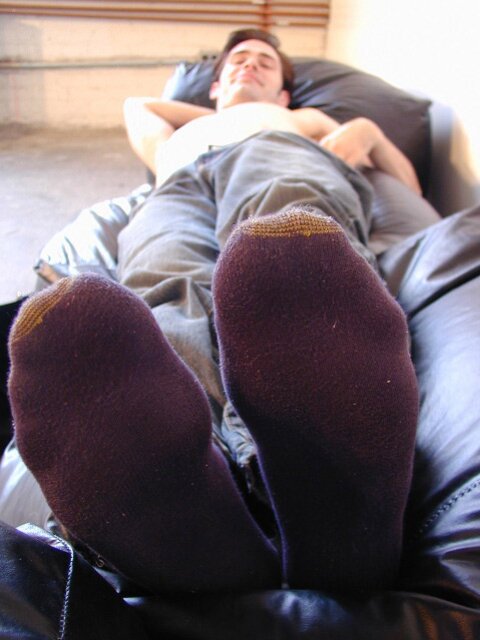 Brunette Christopher flaunts his feet in dark socks for the camera