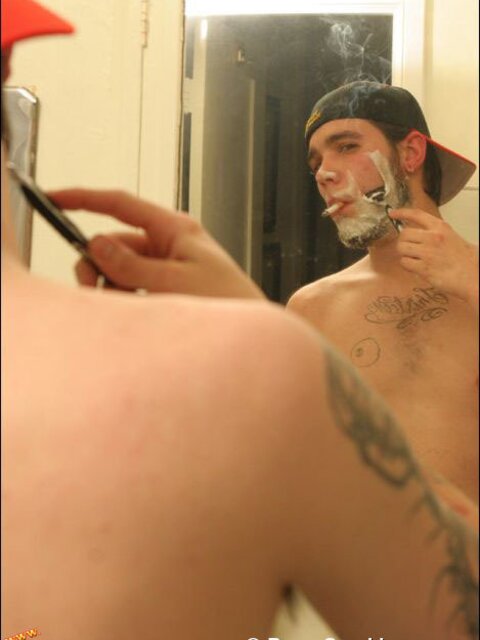 Zack smokes a cigarette while shaving in bathroom