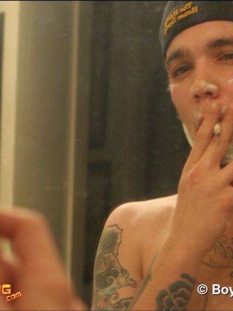 Zack smokes a cigarette while shaving in bathroom