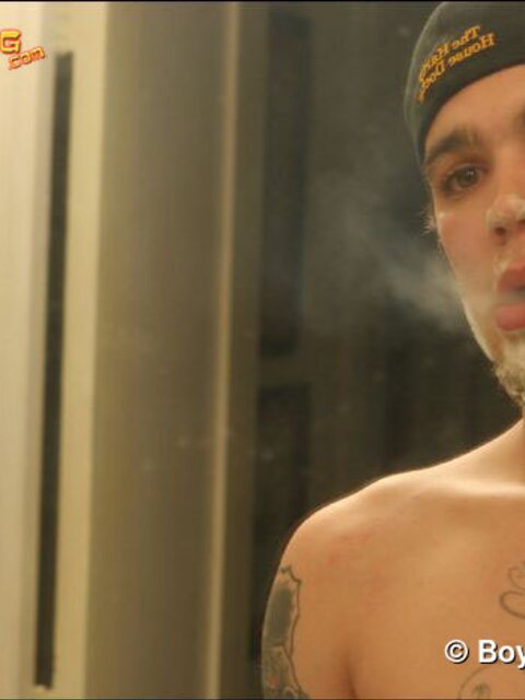 Zack smokes a cigarette while shaving in bathroom