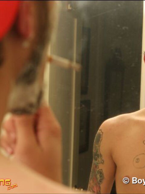 Zack smokes a cigarette while shaving in bathroom