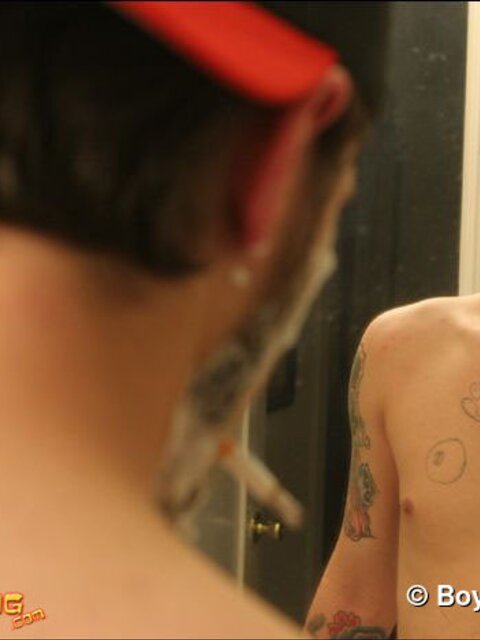 Zack smokes a cigarette while shaving in bathroom