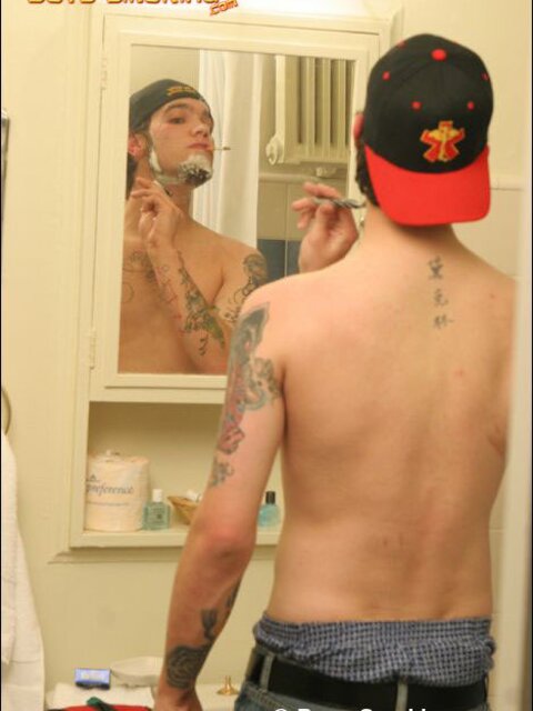 Zack smokes a cigarette while shaving in bathroom