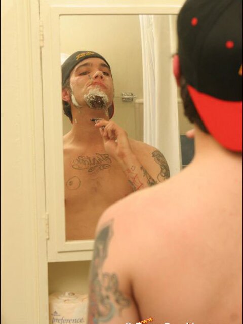 Zack smokes a cigarette while shaving in bathroom