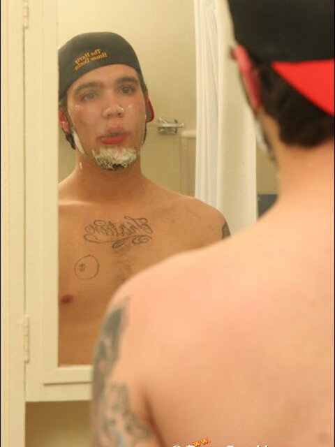 Zack smokes a cigarette while shaving in bathroom