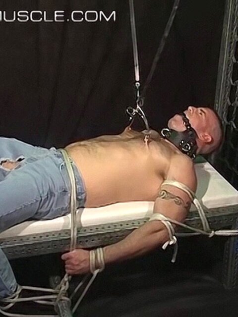Bigg Pete is tied down and gagged before nipple clamps go on