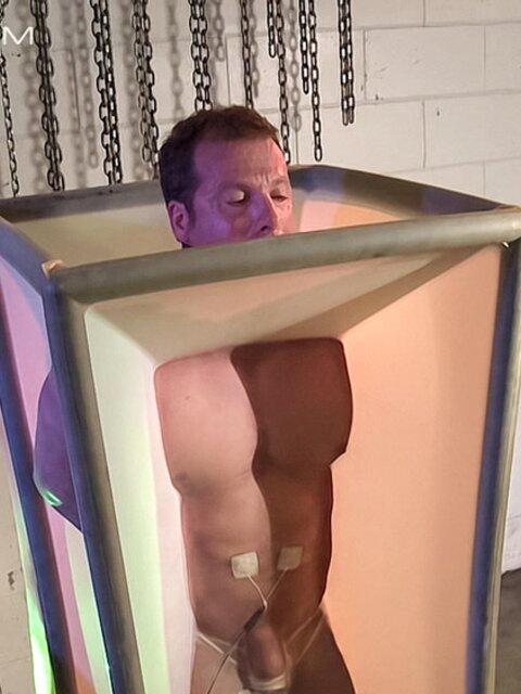 Dire Callahan traps Derek Pain in a latex coffin for pain play