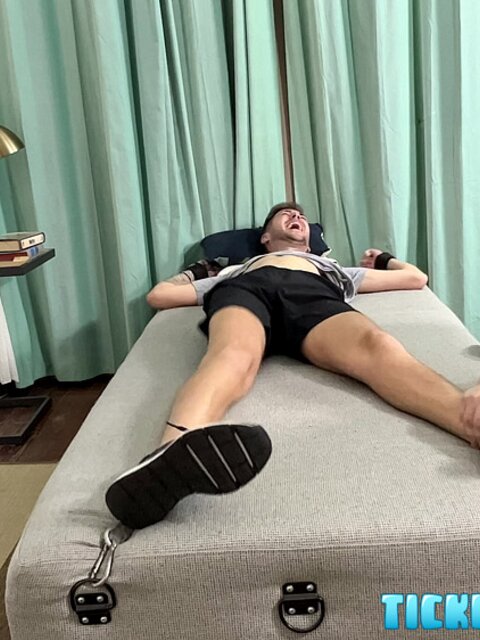 Dimitri laughs hard as Matt tickles his bare feet after gym class