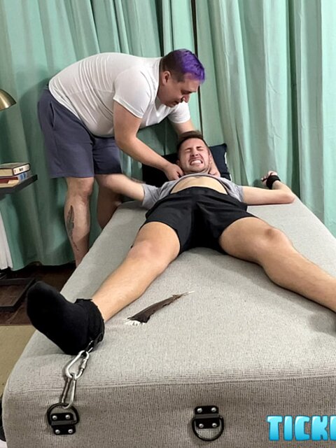 Dimitri laughs hard as Matt tickles his bare feet after gym class