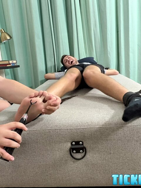 Dimitri laughs hard as Matt tickles his bare feet after gym class
