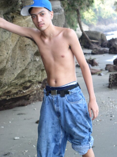 Young twink Adrial gets completely naked on the beach and strokes his cock